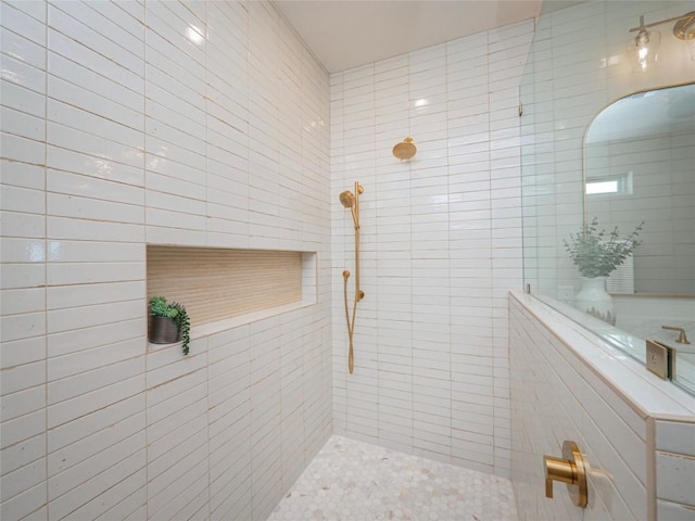 bathroom with a tile shower and tile walls