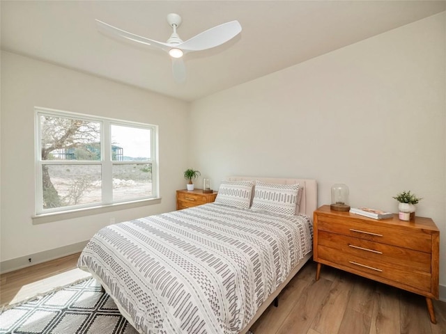 bedroom with light hardwood / wood-style flooring and ceiling fan