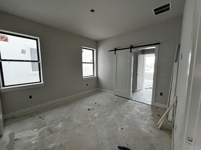 spare room featuring plenty of natural light, a barn door, and a textured ceiling