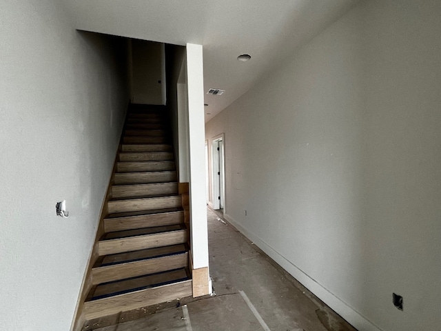 stairs featuring concrete flooring