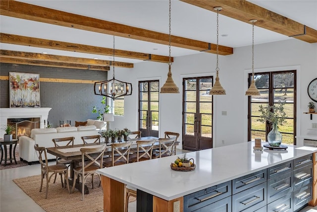 130 Overlook Dr, Fredericksburg, TX 78624 - kitchen with open floor plan, beamed ceiling, pendant lighting, light countertops, and a lit fireplace