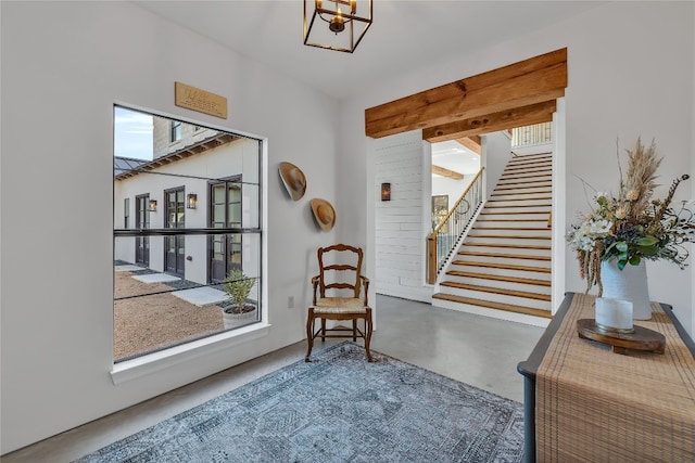 doorway featuring a wealth of natural light, a notable chandelier, and concrete floors