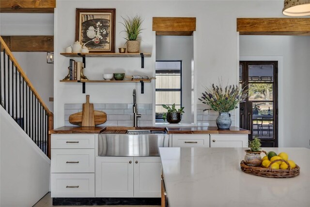 kitchen featuring sink, tasteful backsplash, and white cabinets