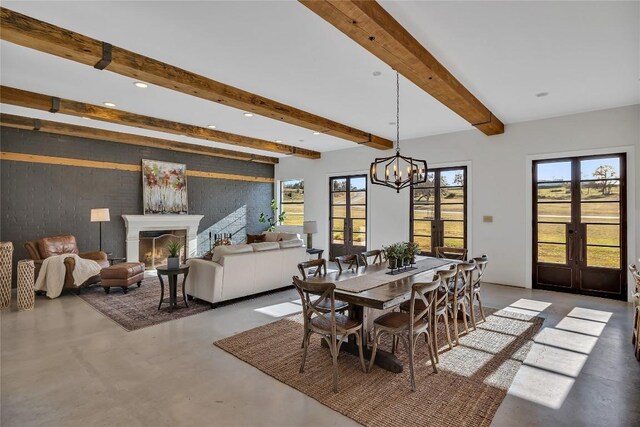 dining space with a wealth of natural light, concrete floors, and beamed ceiling