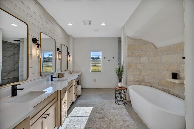 bathroom featuring tile walls, double vanity, and a tub to relax in