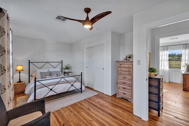 bedroom with ceiling fan, a closet, and light hardwood / wood-style floors