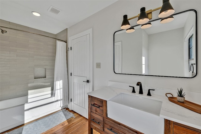 bathroom with plenty of natural light, vanity, shower / tub combo, and wood-type flooring