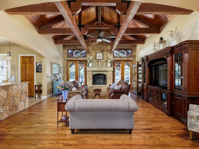 living room featuring ceiling fan, beam ceiling, wood-type flooring, and french doors