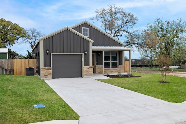 view of front of property featuring central AC unit, a front yard, and a garage