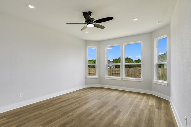 unfurnished room with ceiling fan, light hardwood / wood-style flooring, and a wealth of natural light