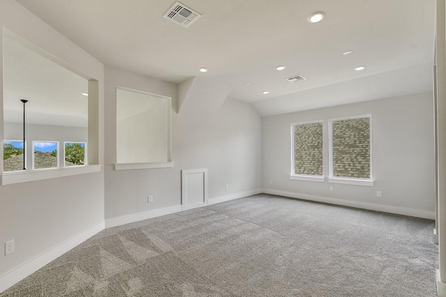 carpeted spare room with lofted ceiling