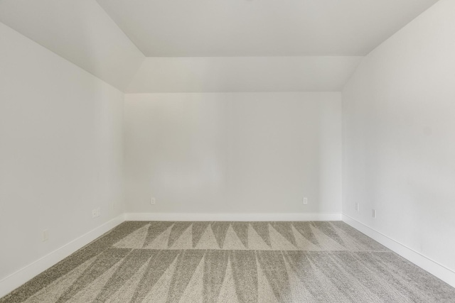 empty room featuring lofted ceiling and carpet floors