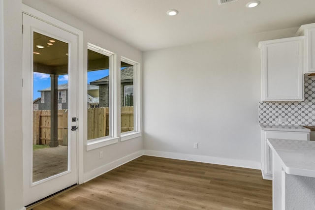 unfurnished dining area featuring hardwood / wood-style floors and plenty of natural light