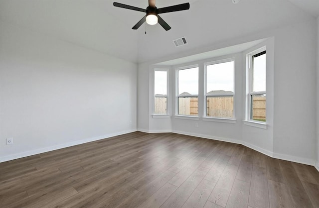 empty room with dark wood-type flooring, ceiling fan, and vaulted ceiling