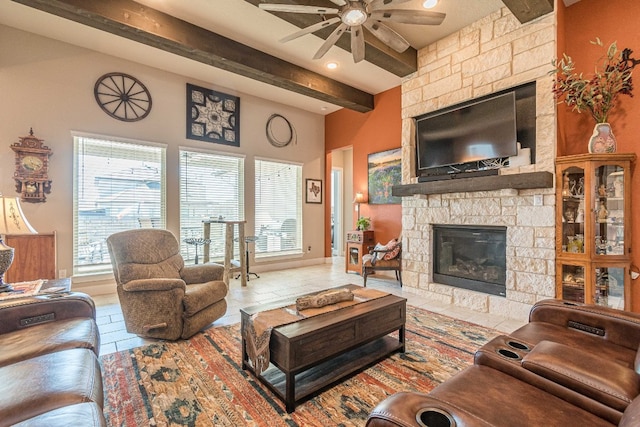 living room with ceiling fan, a stone fireplace, light tile floors, and beam ceiling