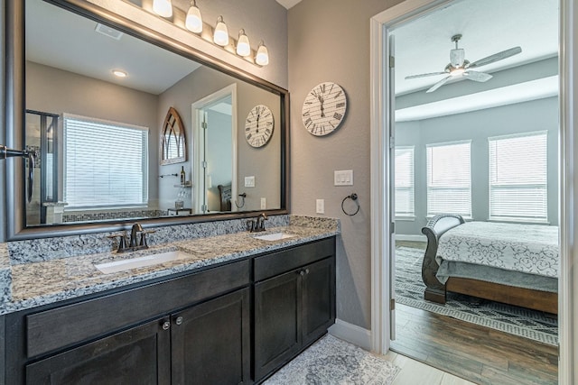 bathroom featuring dual sinks, oversized vanity, hardwood / wood-style flooring, and ceiling fan