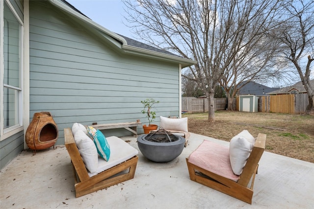 view of patio / terrace with a fire pit and a storage unit