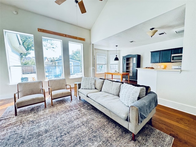 living room featuring dark hardwood / wood-style floors, ceiling fan, and lofted ceiling