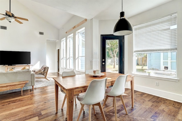 dining room featuring hardwood / wood-style flooring, high vaulted ceiling, and ceiling fan