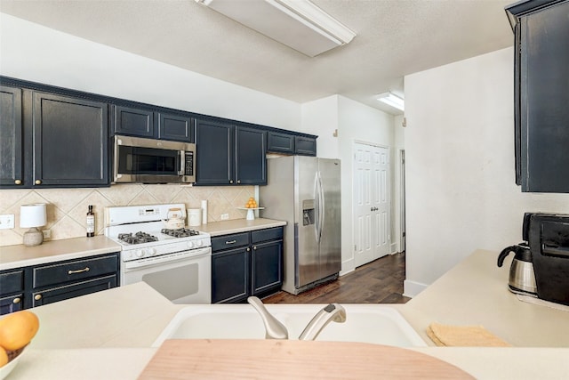 kitchen featuring appliances with stainless steel finishes, dark hardwood / wood-style floors, tasteful backsplash, and sink