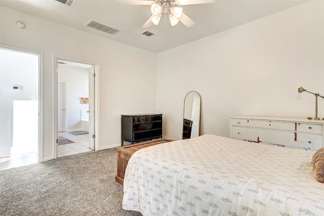 bedroom with ensuite bath, light carpet, and ceiling fan