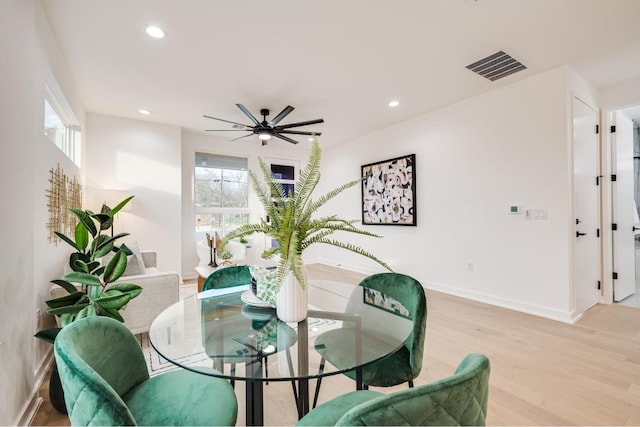 dining space with ceiling fan and light wood-type flooring