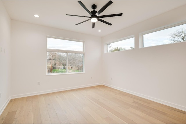 unfurnished room featuring ceiling fan, a wealth of natural light, and light wood-type flooring