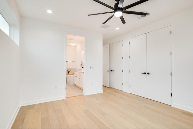 unfurnished bedroom featuring ceiling fan, ensuite bathroom, and light hardwood / wood-style flooring