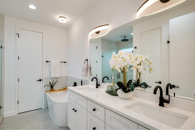 bathroom featuring a bathtub, double vanity, and tile flooring