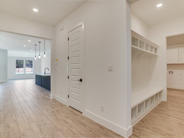 mudroom with sink and light wood-type flooring