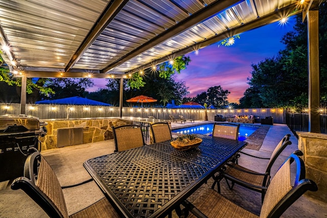 patio terrace at dusk featuring a fenced in pool