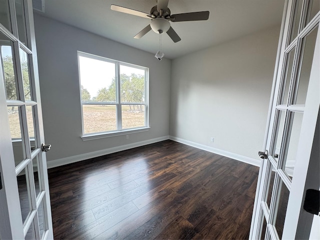 spare room with ceiling fan, french doors, and dark wood-type flooring