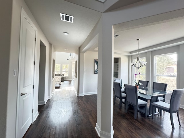 dining room featuring dark wood-type flooring and a chandelier