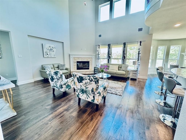 101 Gabwood Ct, Georgetown, TX 78633 - living area featuring dark wood finished floors, healthy amount of natural light, baseboards, a glass covered fireplace, and a high ceiling