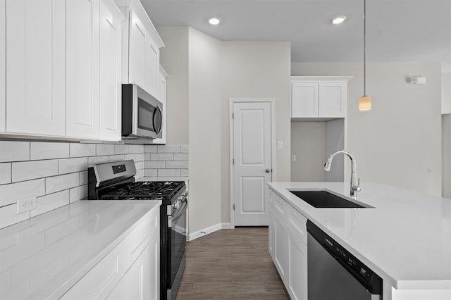 kitchen featuring white cabinetry, sink, stainless steel appliances, backsplash, and pendant lighting