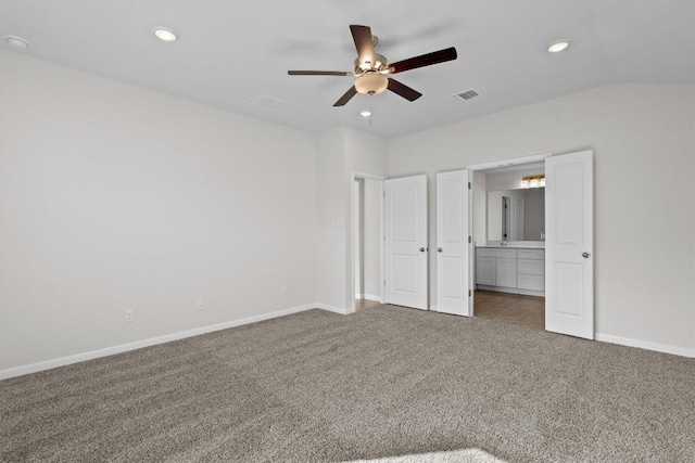 unfurnished bedroom featuring baseboards, visible vents, vaulted ceiling, carpet floors, and recessed lighting