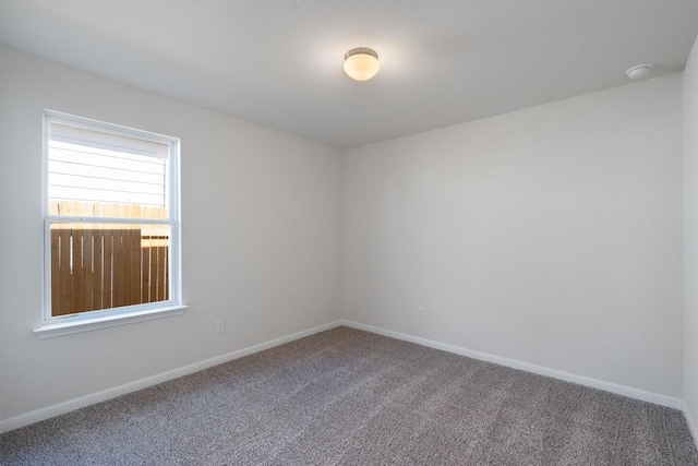 spare room featuring carpet floors and baseboards