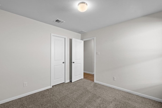 unfurnished bedroom featuring carpet floors, visible vents, and baseboards