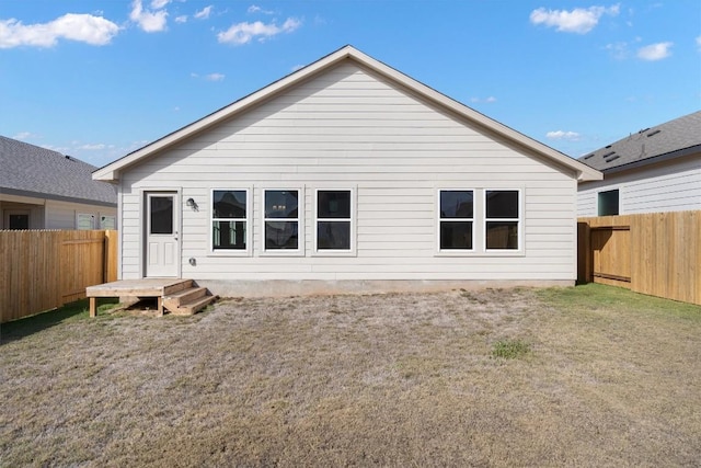 back of house featuring a fenced backyard and a yard