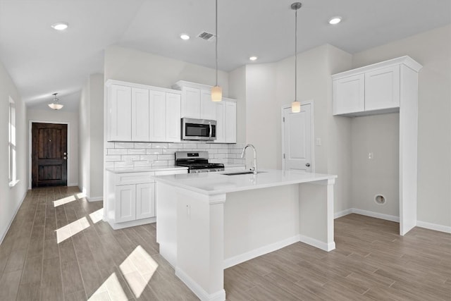 kitchen featuring tasteful backsplash, visible vents, white cabinets, appliances with stainless steel finishes, and a sink