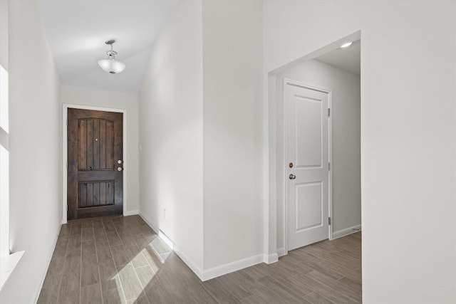 entryway with baseboards, lofted ceiling, and wood tiled floor