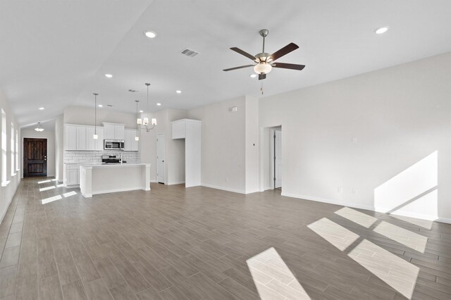 unfurnished living room featuring ceiling fan with notable chandelier and lofted ceiling