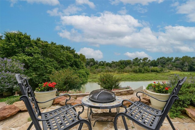 view of patio / terrace with a water view and an outdoor fire pit