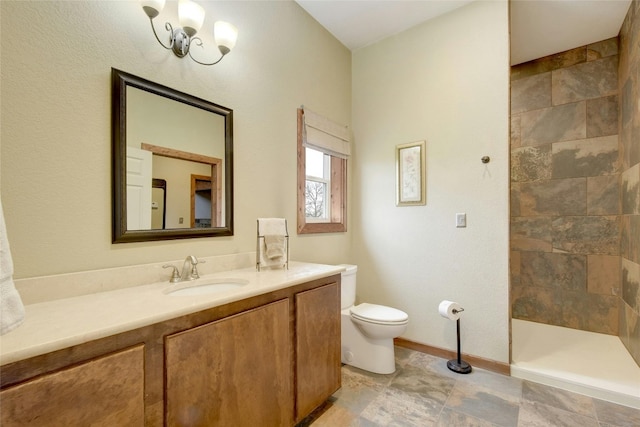 bathroom featuring tiled shower, vanity, and toilet