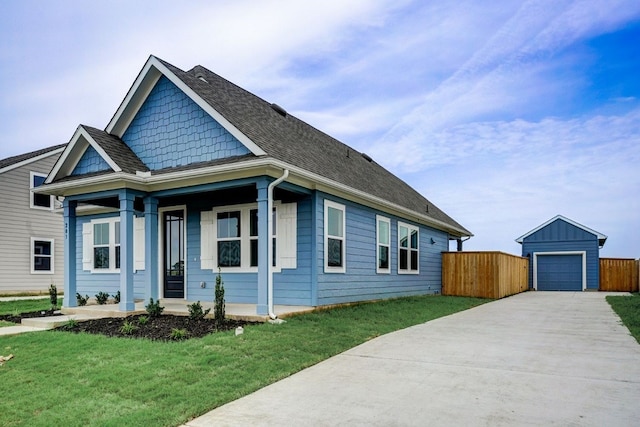 view of front of house featuring an outdoor structure, a front lawn, and a garage