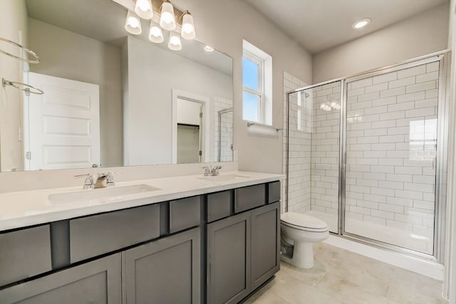 bathroom with toilet, a shower with shower door, vanity, and tile patterned flooring