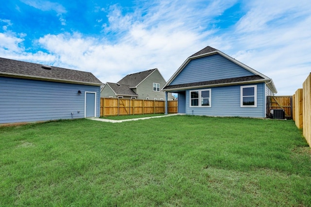 rear view of house with a yard and cooling unit