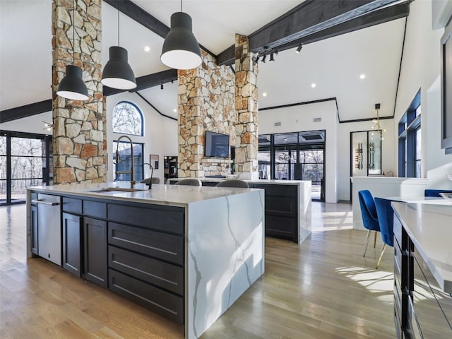 kitchen featuring beam ceiling, high vaulted ceiling, pendant lighting, hardwood / wood-style floors, and dishwasher