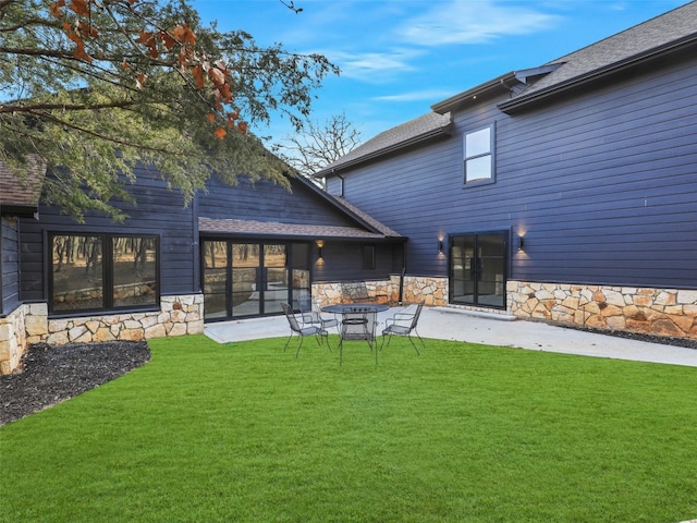 rear view of property with a yard and a patio area