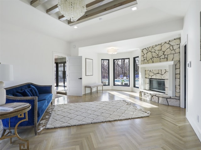 living room featuring a fireplace, beam ceiling, and light parquet flooring